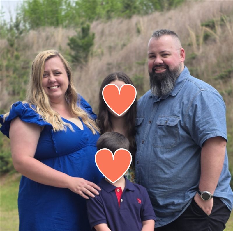 Jay Sweeney, founder of Cardible, outdoors with his wife Alicia and their two children, whose faces are covered by heart graphics.